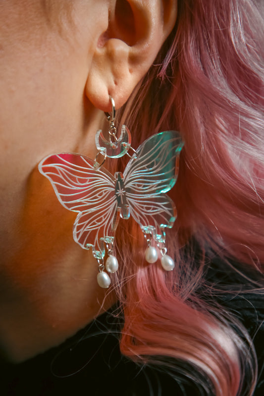 Large butterfly iridescent acrylic earrings with pearls worn with pink hair
