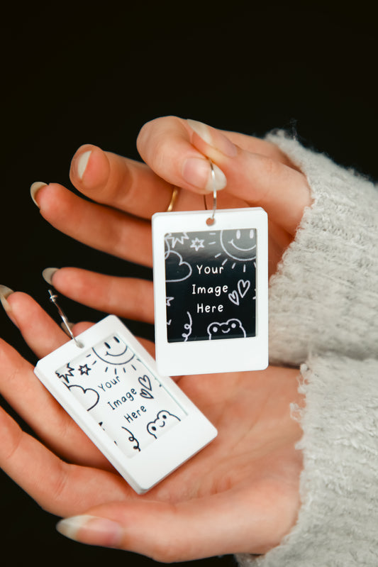 Polaroid acrylic earrings being held by hands