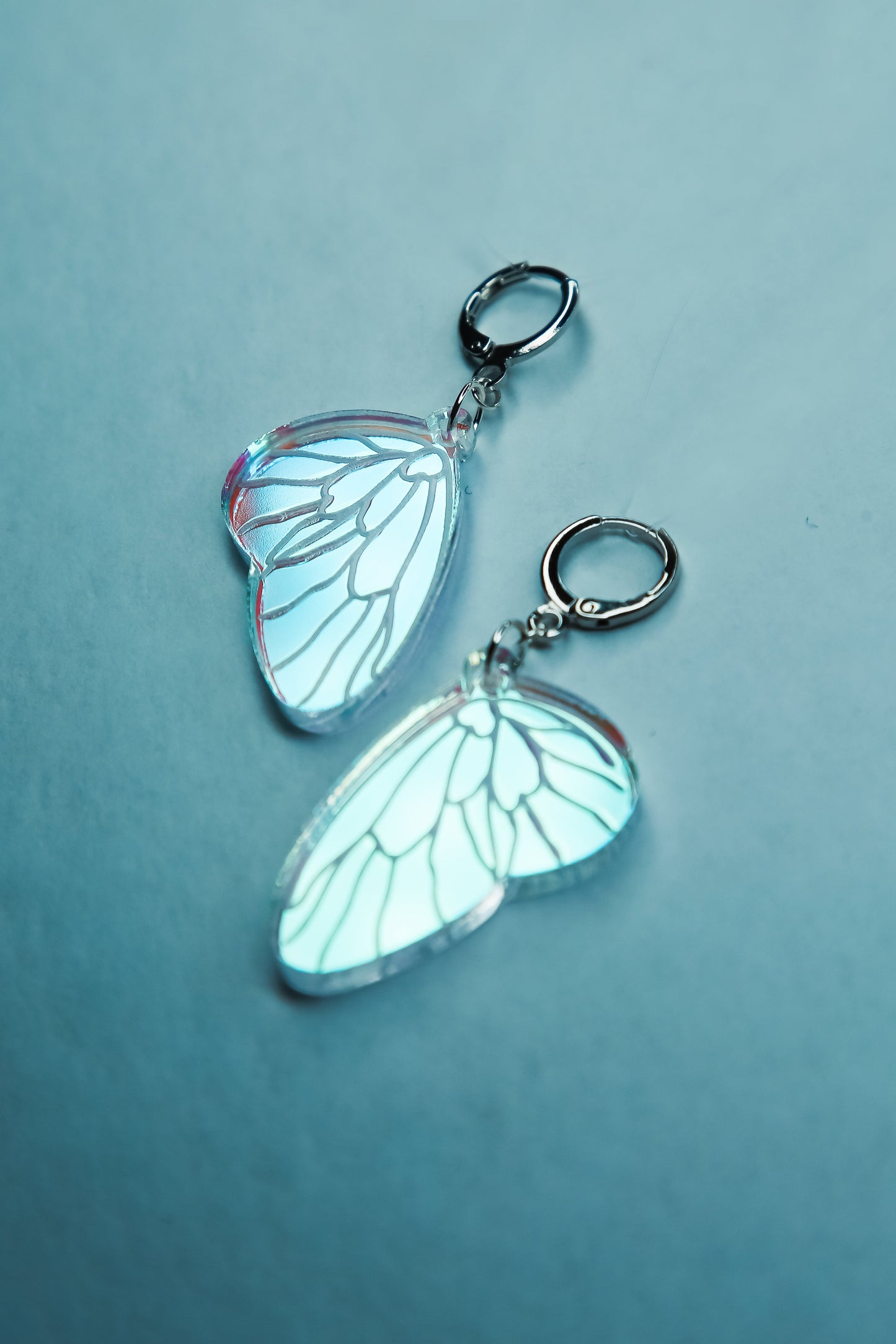 A flat lay of mini iridescent acrylic earrings styled after a fairies wing