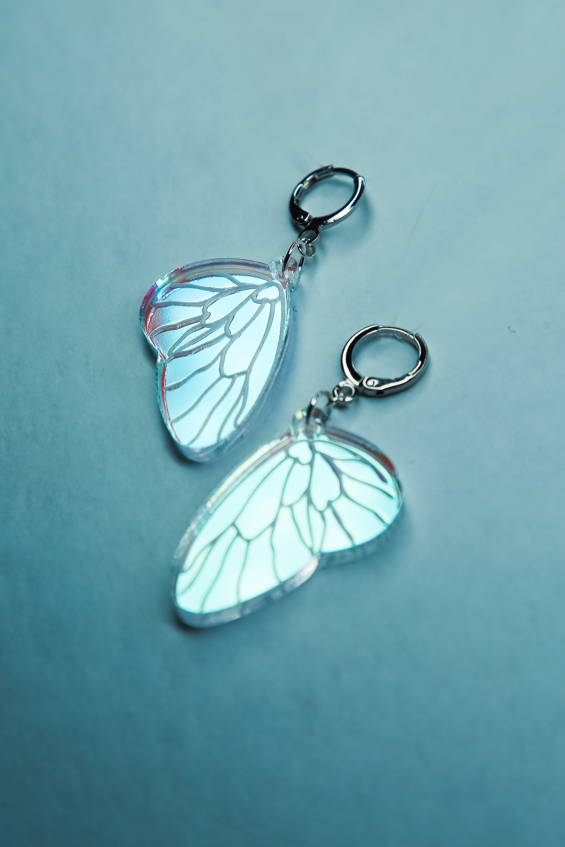 A flat lay of mini iridescent acrylic earrings styled after a fairies wing