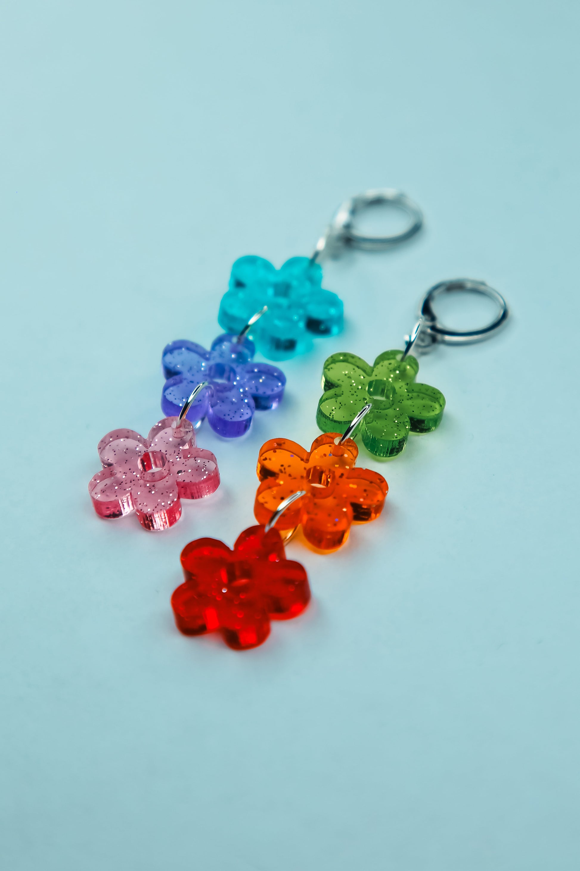 a flat lay of multi coloured flower acrylic earrings 