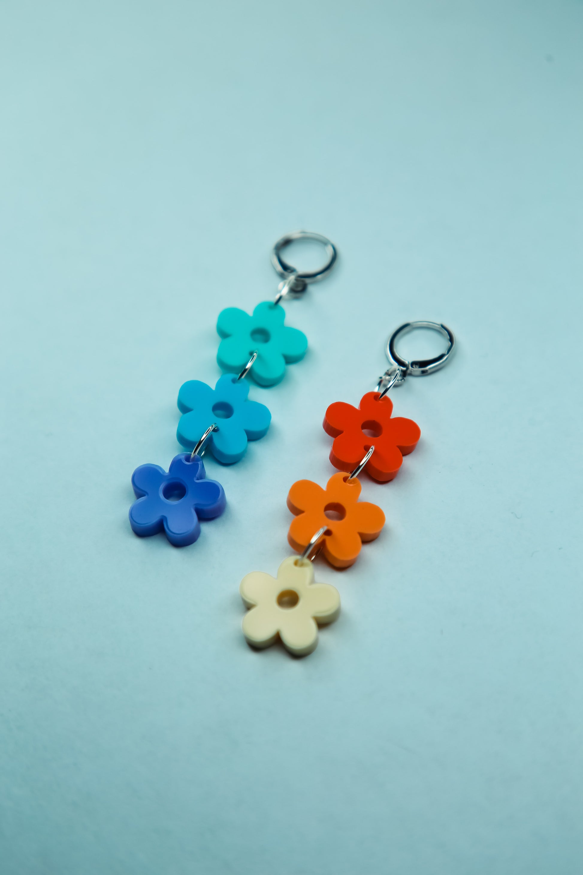 a pair of multi coloured pastel flower acrylic earrings flat lay