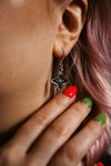 small silver star with reflective material against pink hair