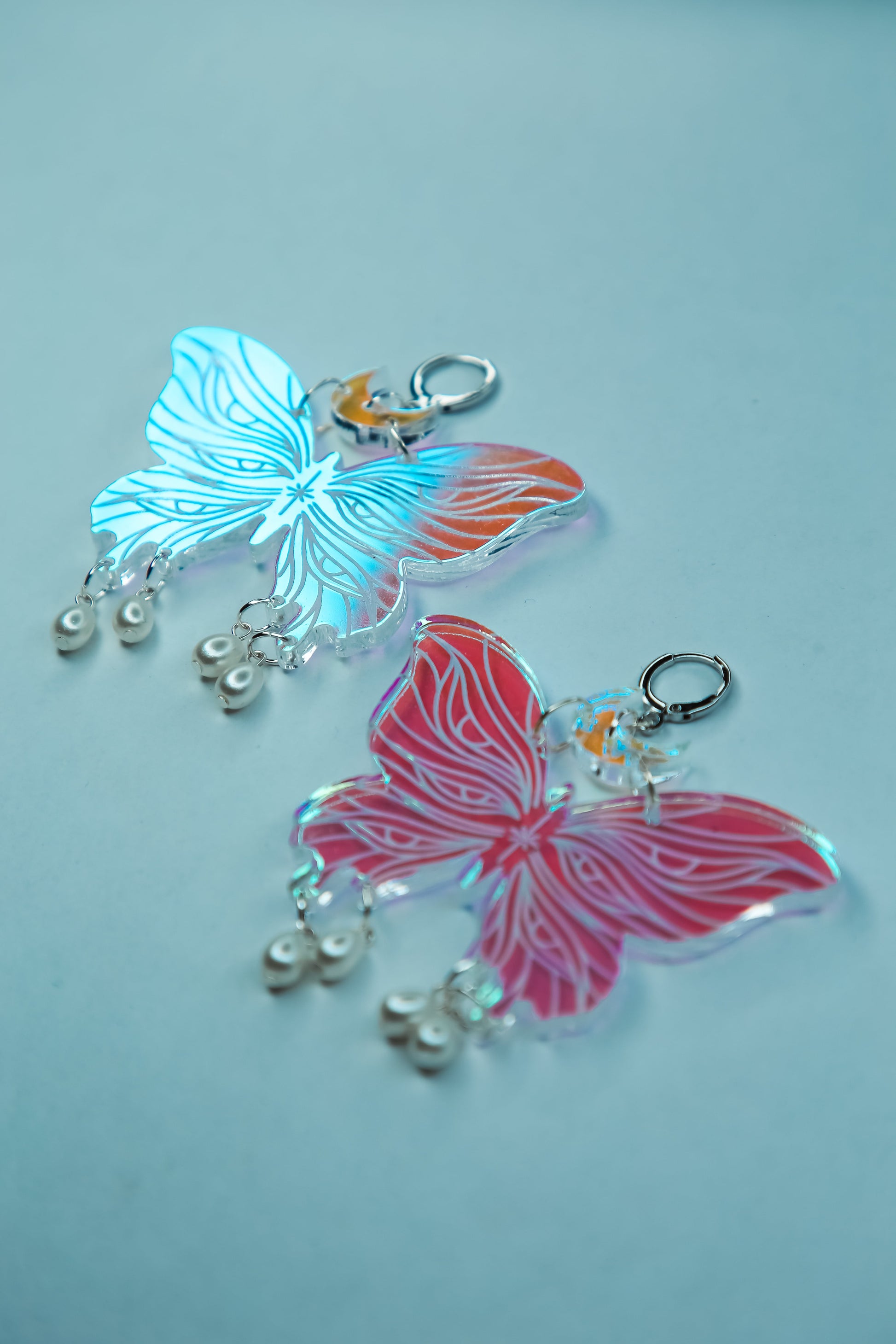 Two large butterfly iridescent acrylic earrings with pearls